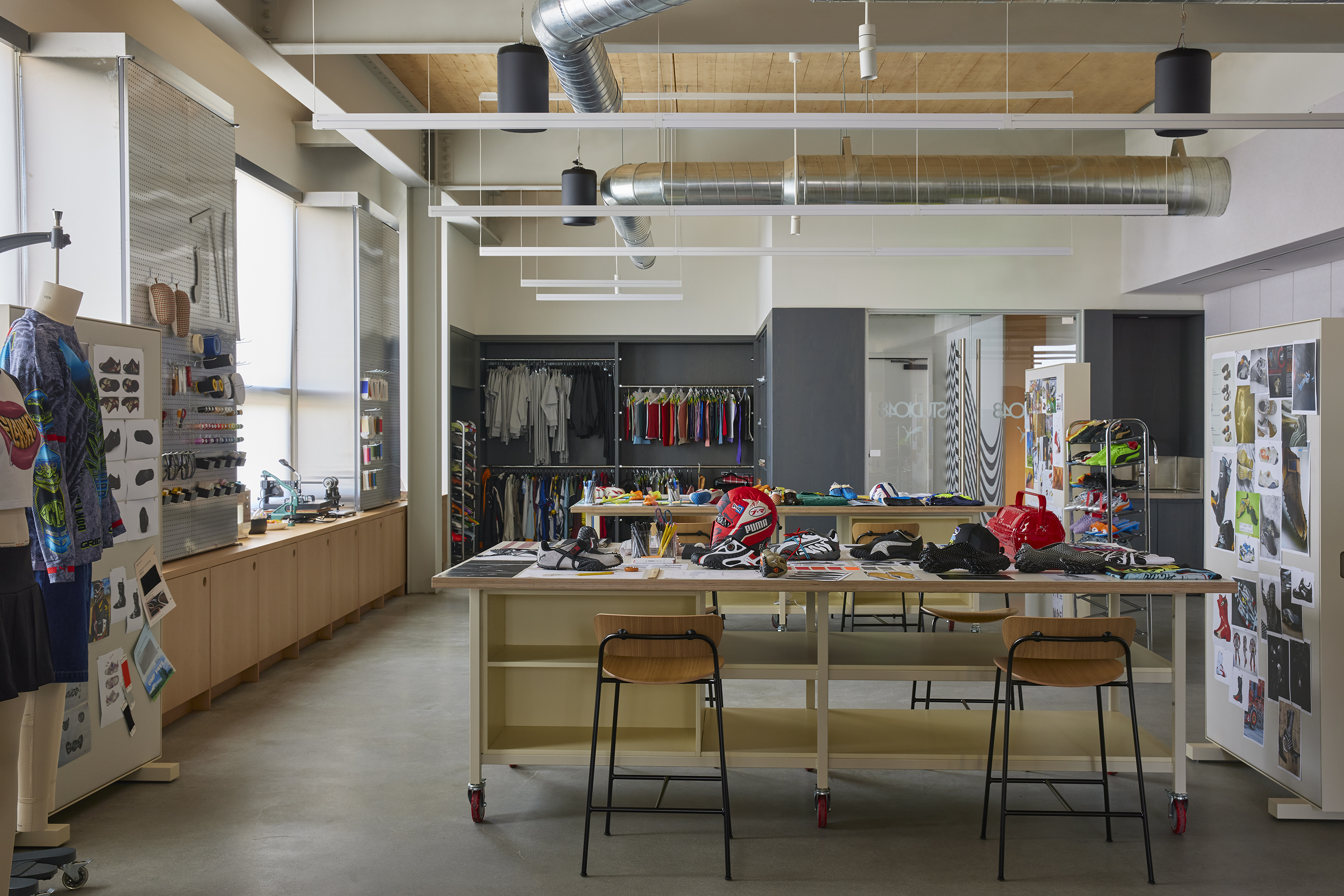 Sample workshop with rolling tables, garment rails and pinned reference boards