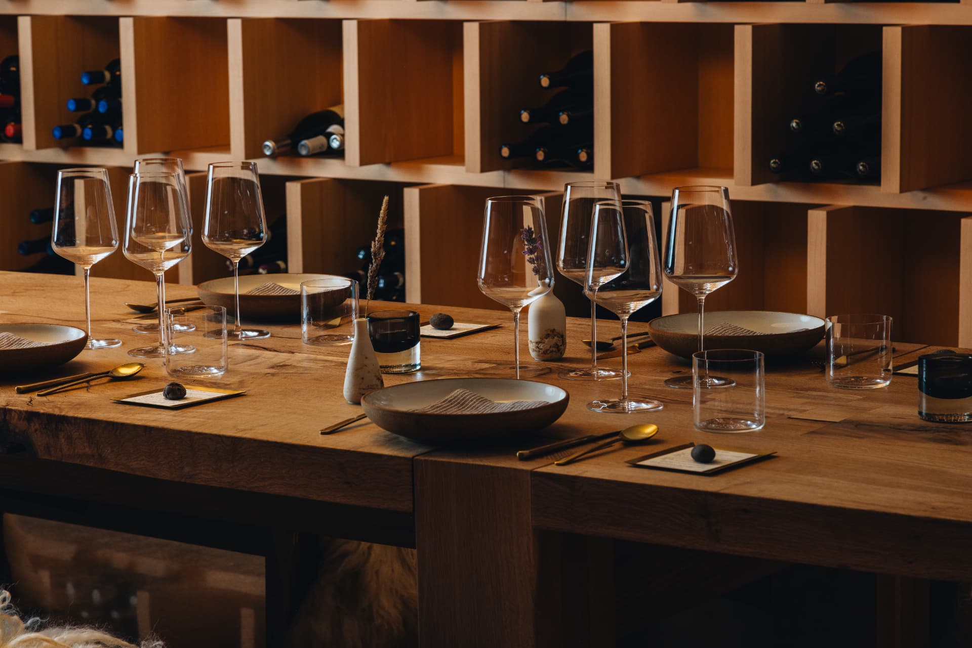 Glasses, ceramic bowls and place settings along the oak table