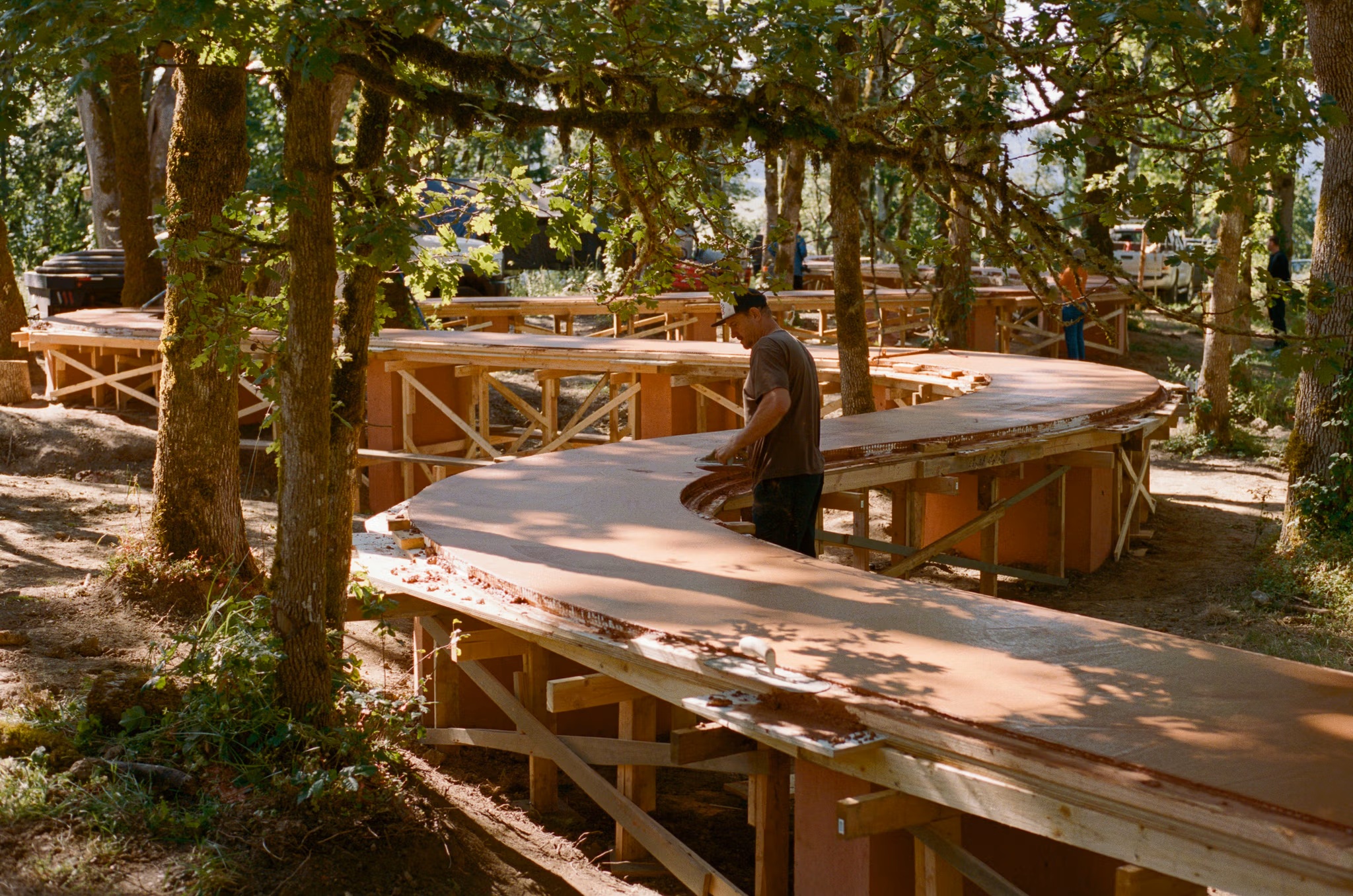 Curving formwork and freshly cast terrazzo table under construction among the trees