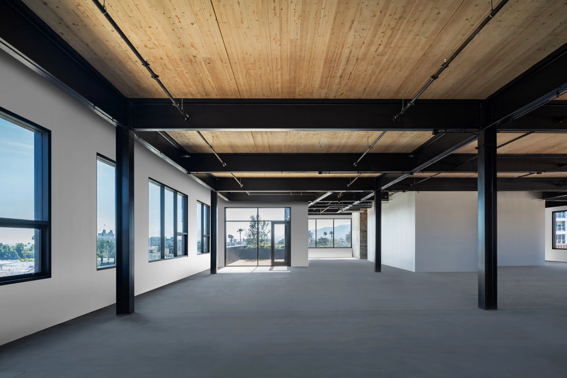 Open workplace floor with black steel frame and exposed timber ceiling