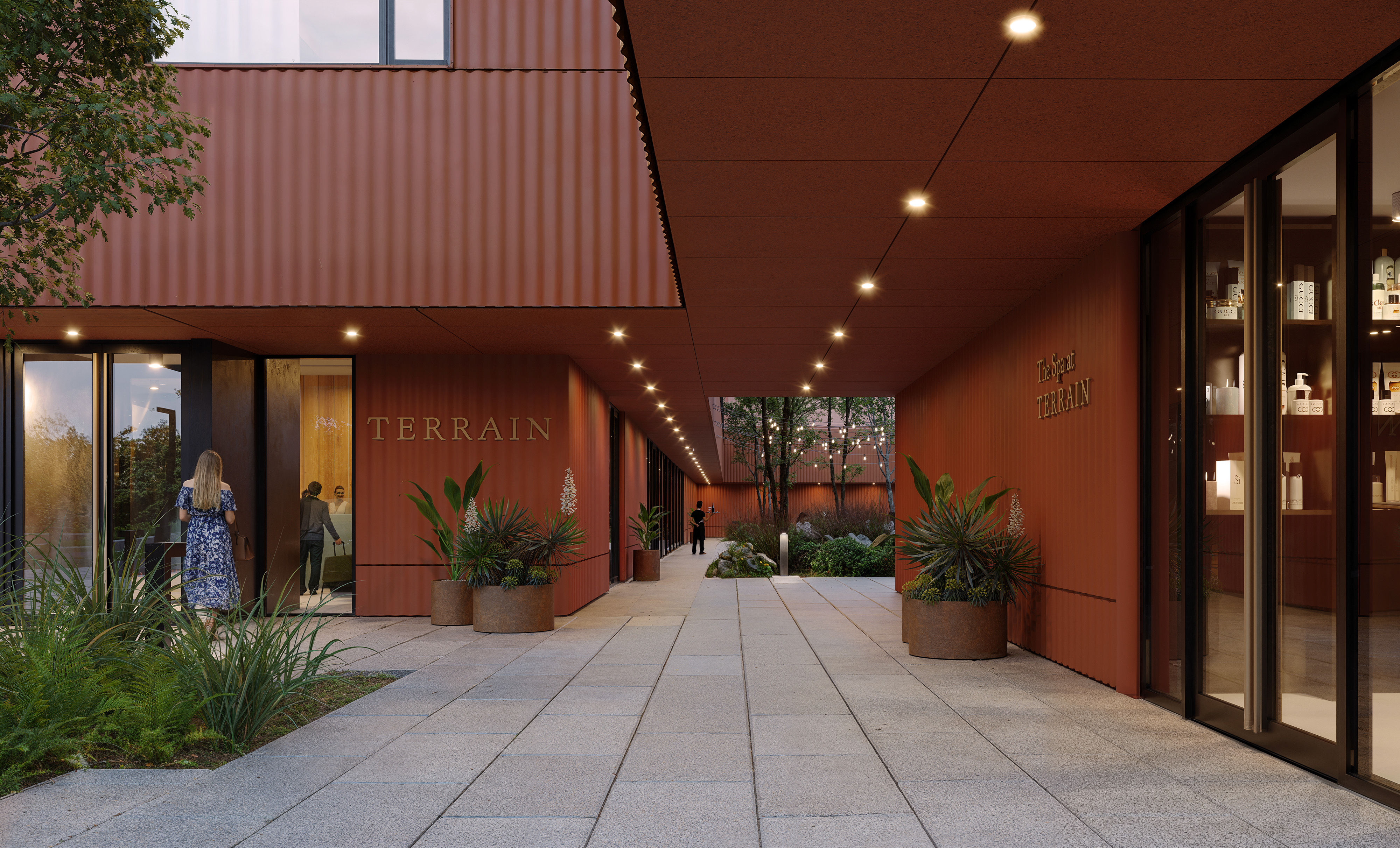Sheltered entry colonnade with Terrain Hotel signage, spa storefront and a planted courtyard beyond
