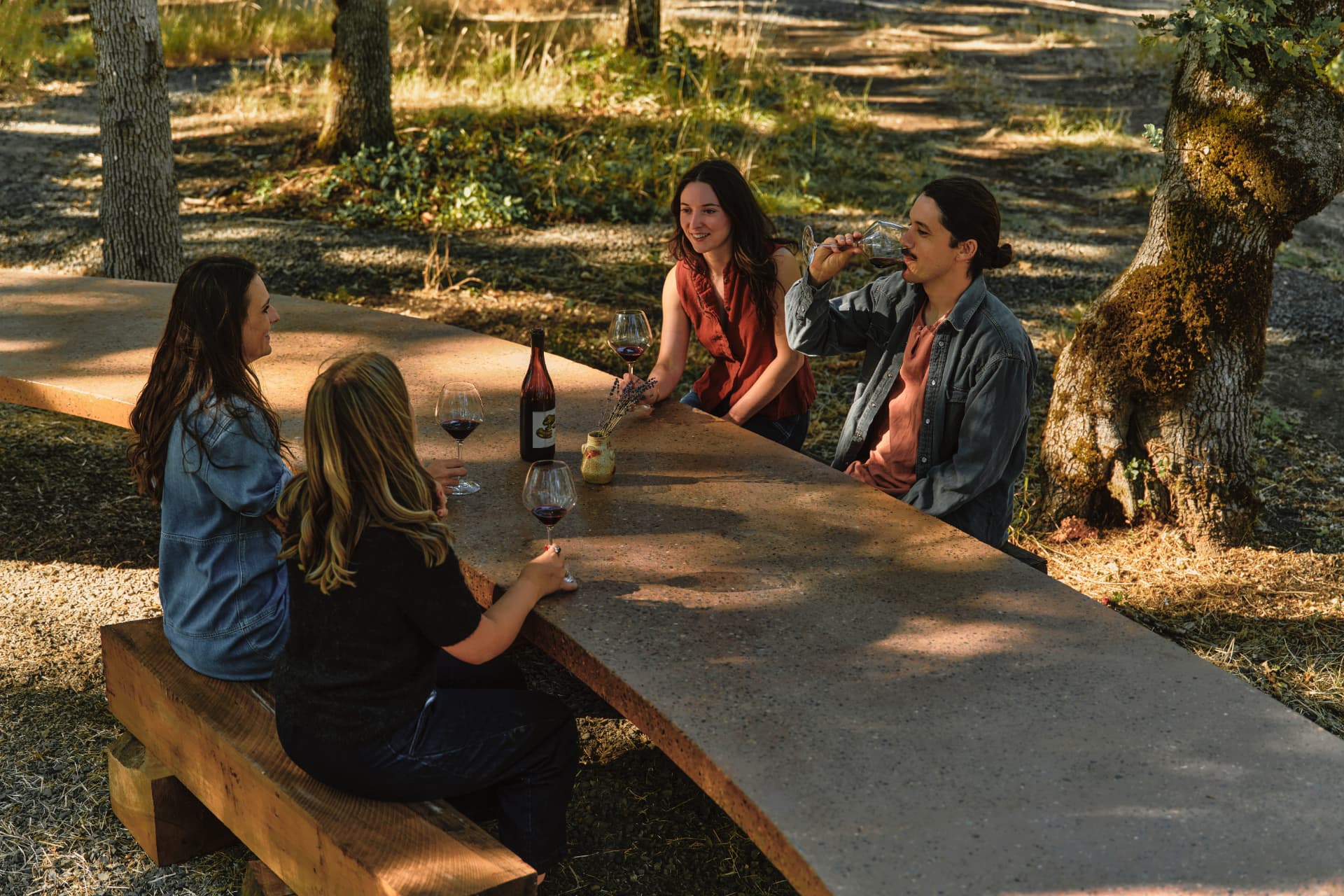 Overhead view of four guests with wine glasses along the terrazzo table