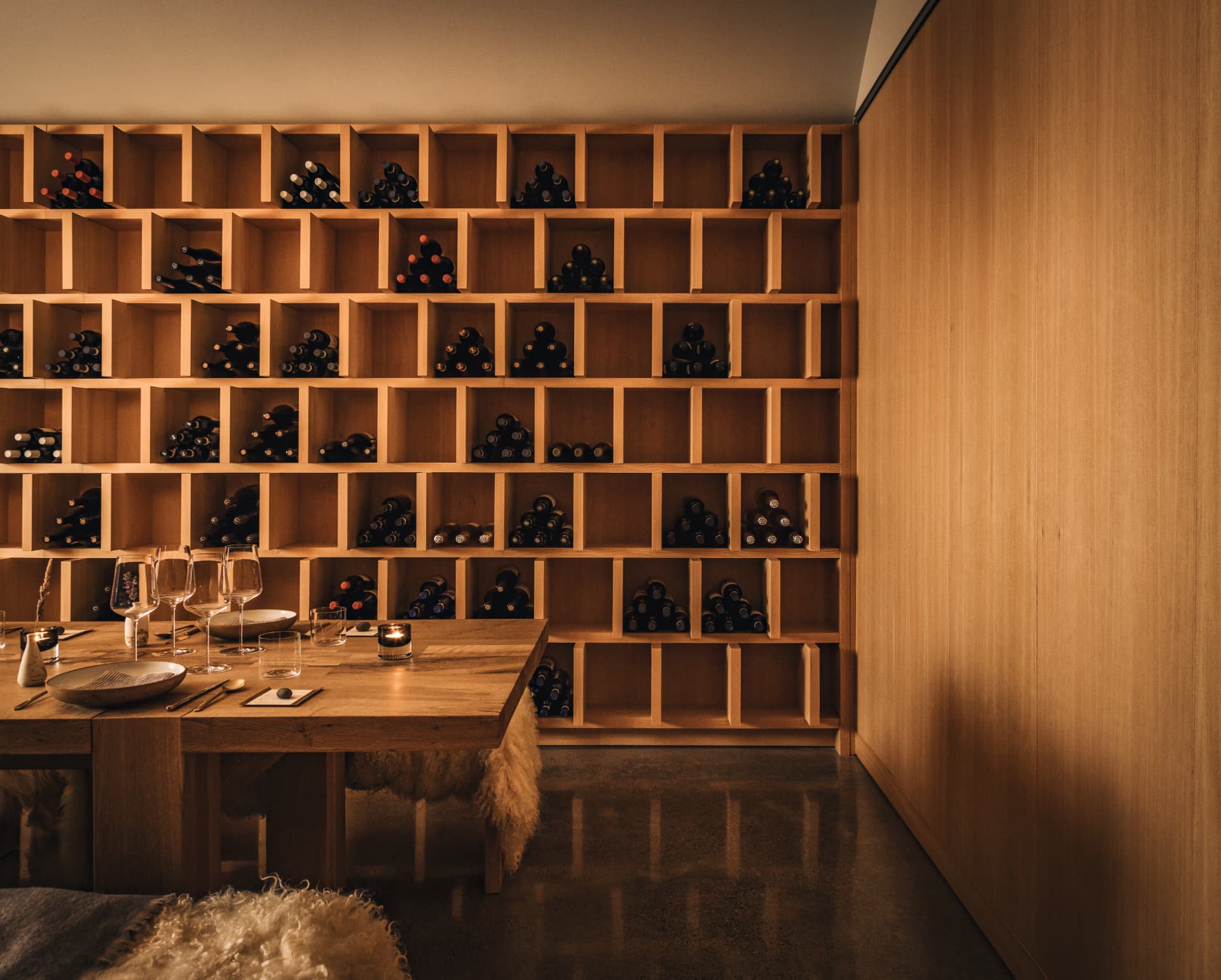 Full wine-cube wall with the dining table set below