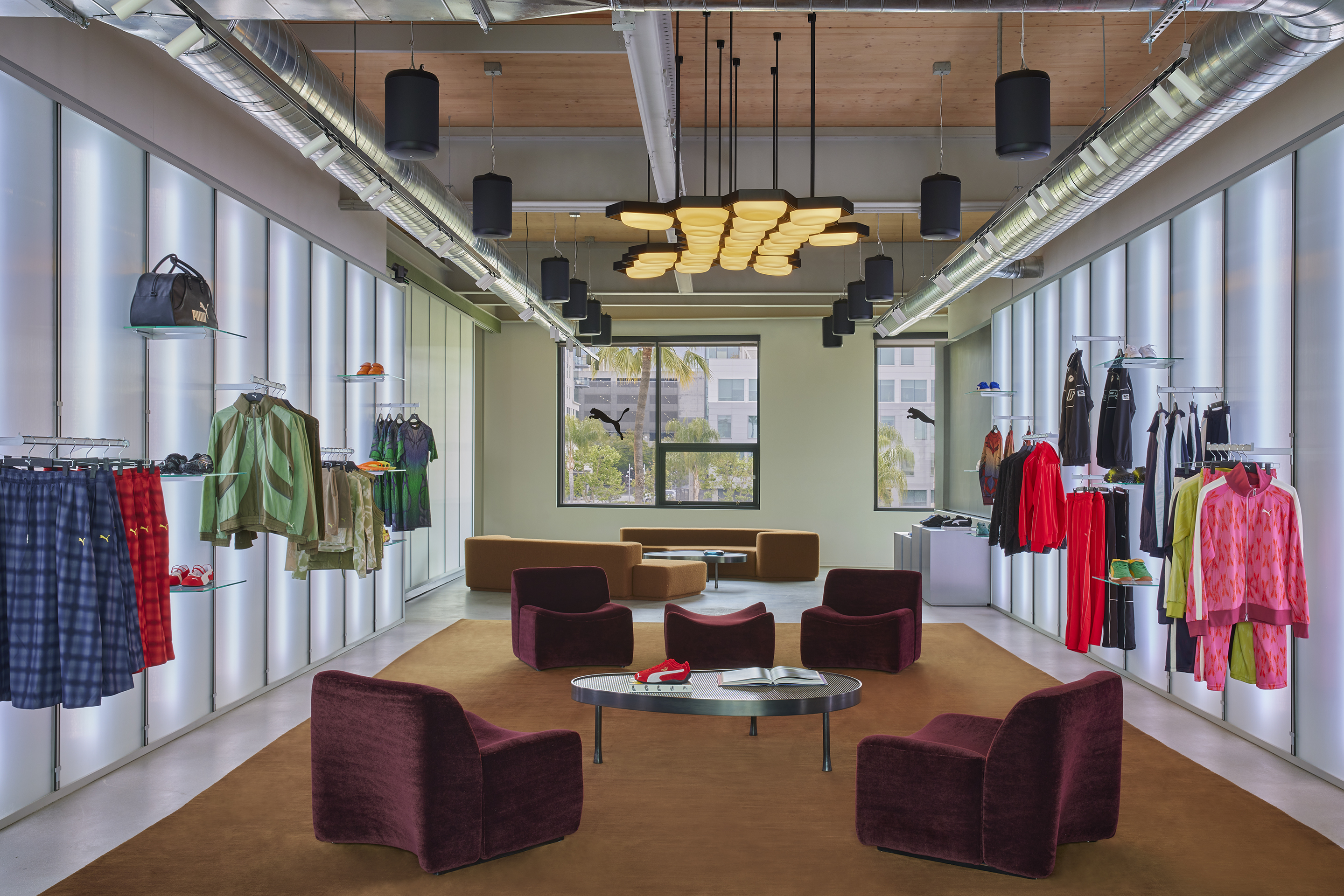 Showroom with backlit walls, maroon lounge chairs and a rust rug