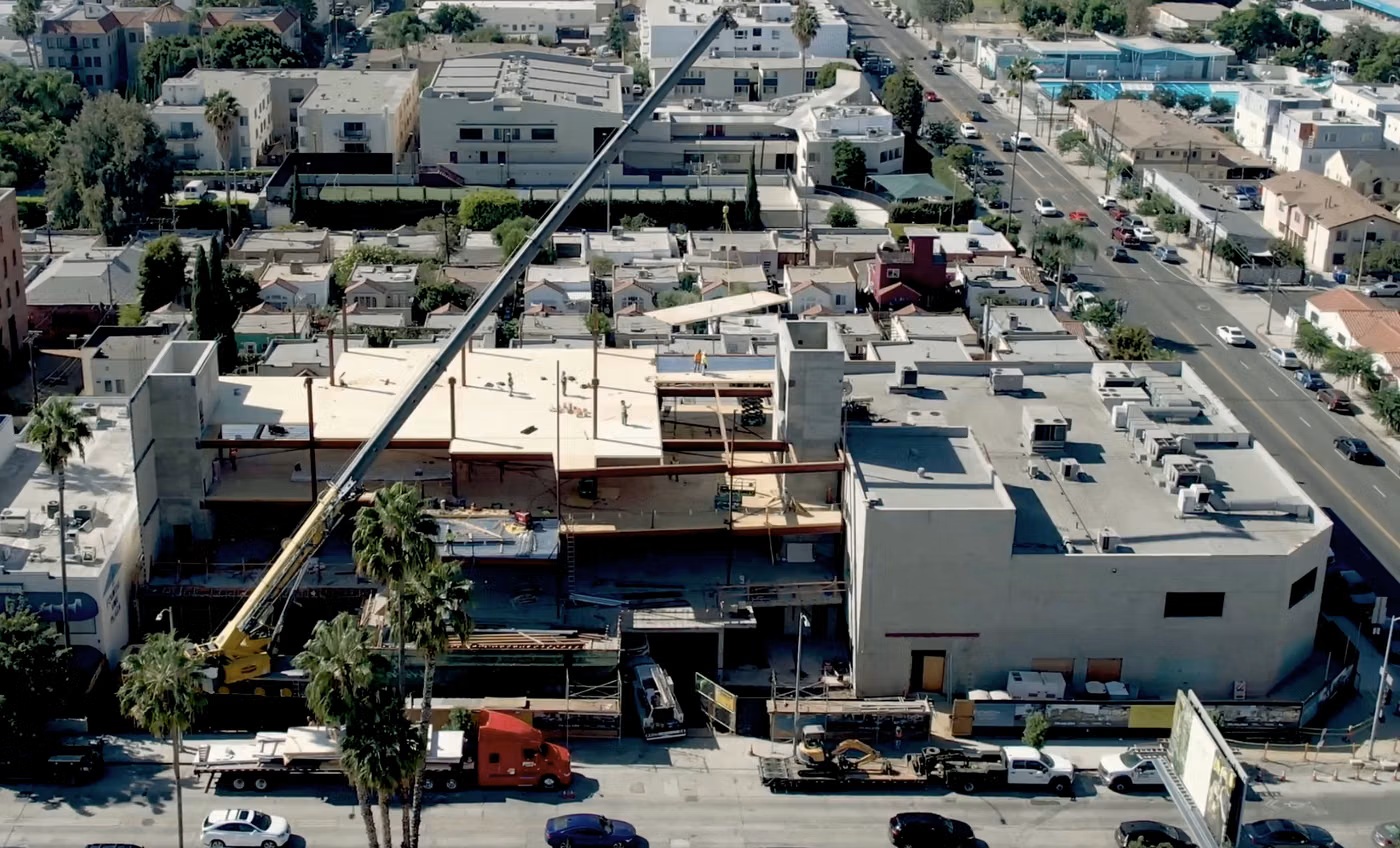 Aerial view of the site during construction with a crane setting timber panels